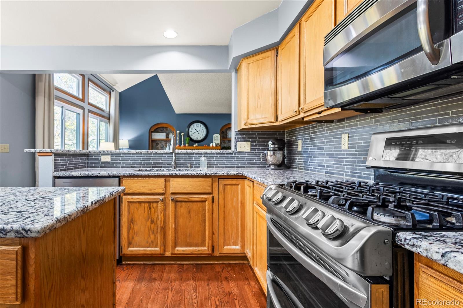 17538 East Baker Place Aurora, CO 80013 - Photo 14 of 50 a kitchen with granite countertop stainless steel appliances and wooden cabinets