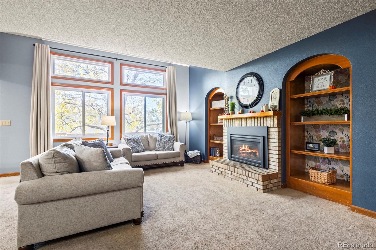 17538 East Baker Place Aurora, CO 80013 - Photo 17 of 50 a living room with furniture a fireplace and a large window