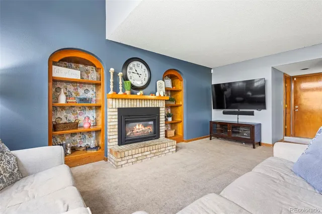a living room with fireplace furniture and a flat screen tv