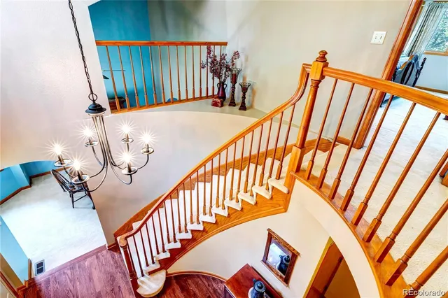 a view of staircase with lots of frames on wall and a wooden floor