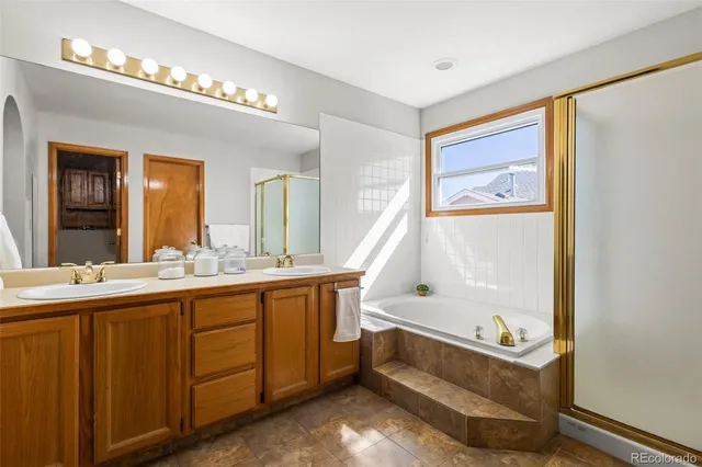 a bathroom with a tub a sink and a mirror