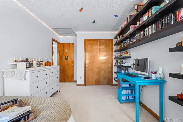 a bedroom with furniture a flat screen tv and a book shelf