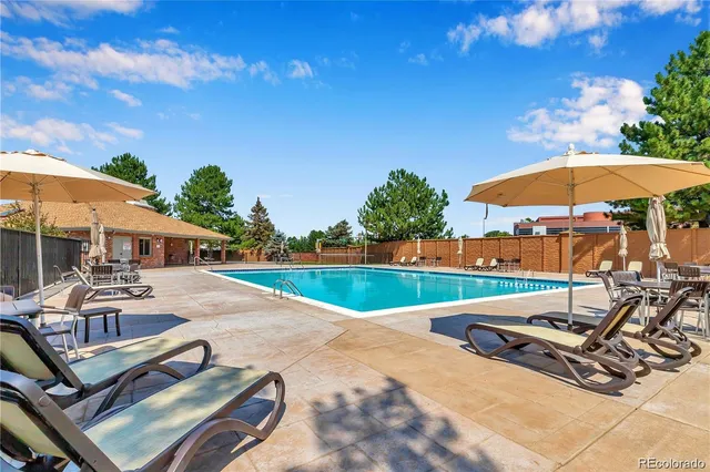 a view of a patio with a table and chairs under an umbrella