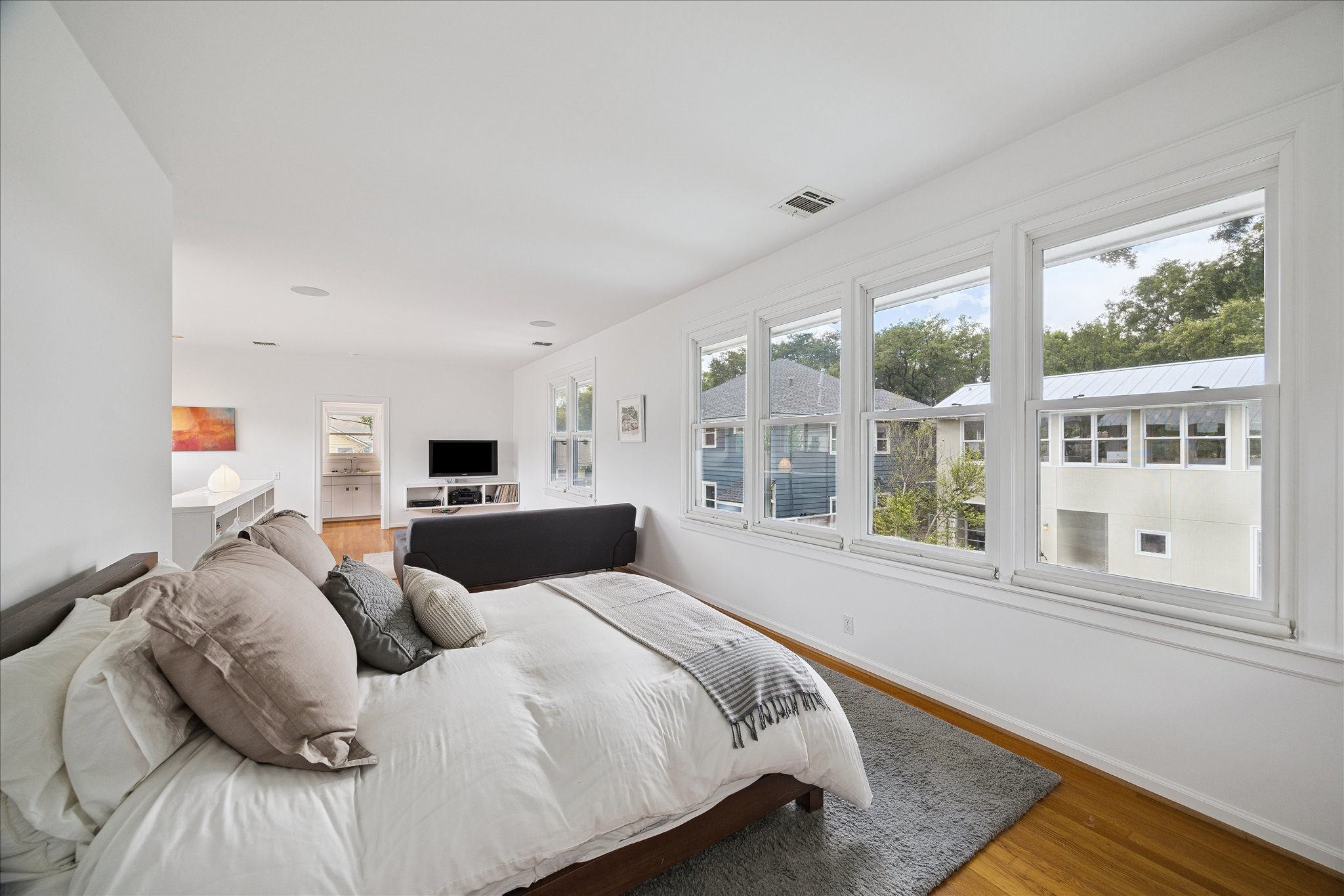 1418 Kipling Street Houston, TX 77006 - Photo 18 of 42 This is a great view showing how expansive the bedroom space feels, while also getting a sense of being able to view the grounds from the endless number of double paned windows that are a consequential design feature of this home.