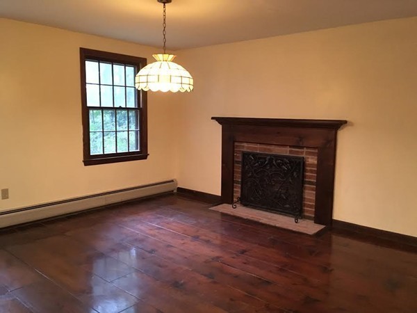 76 Proctor Road Townsend, MA 01469 - Photo 5 of 30 a view of an empty room with wooden floor fireplace and a window