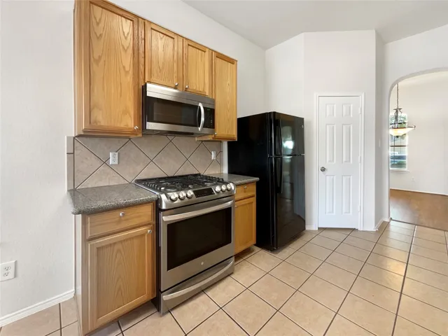 a kitchen with stainless steel appliances granite countertop a refrigerator stove and microwave