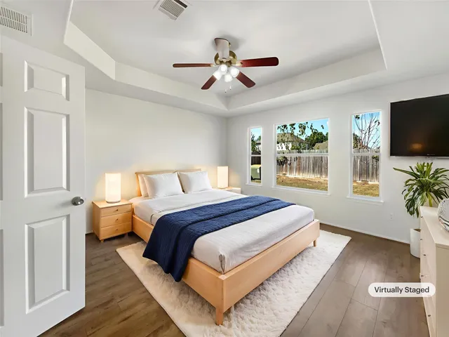 a bedroom with bed tv and window