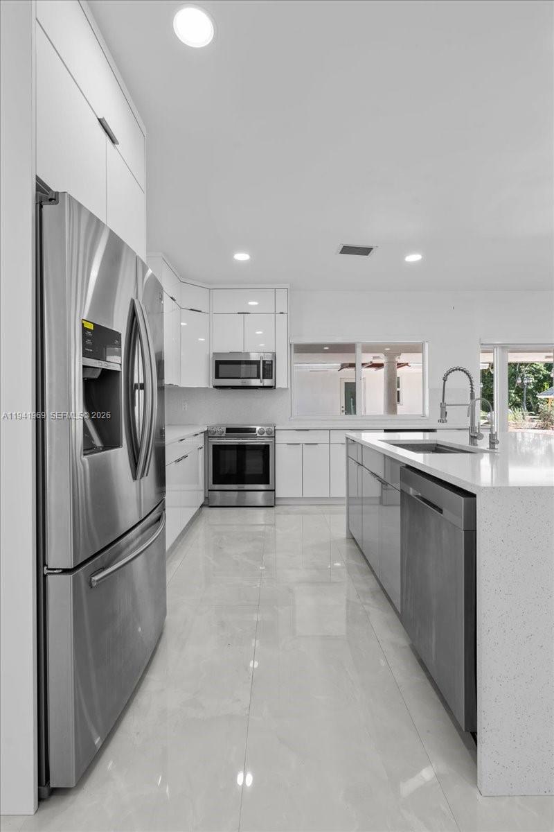 24555 Southwest 167th Avenue, Unit 1 Homestead, FL 33031 - Photo 11 of 33 a kitchen with stainless steel appliances granite countertop a refrigerator sink and stove