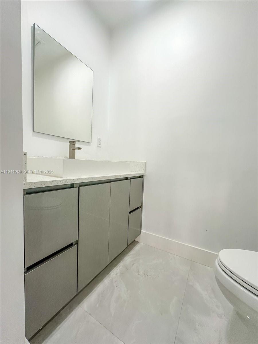 24555 Southwest 167th Avenue, Unit 1 Homestead, FL 33031 - Photo 20 of 33 a bathroom with a toilet sink and mirror