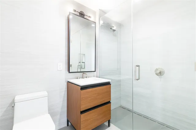 a bathroom with a sink a toilet and shower