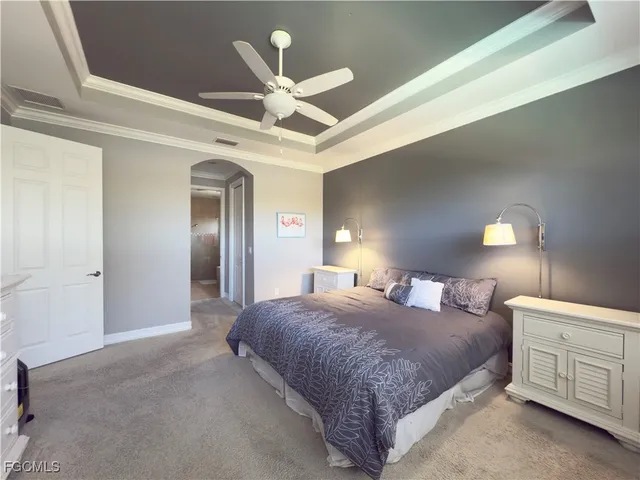 a spacious bedroom with a large bed a chandelier and closet