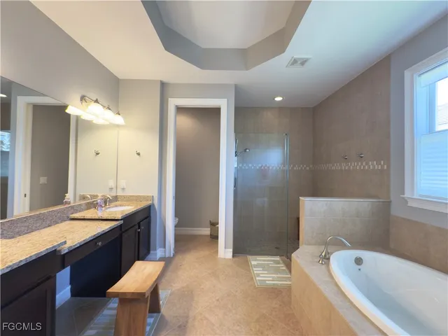 a spacious bathroom with a bathtub sink and mirror