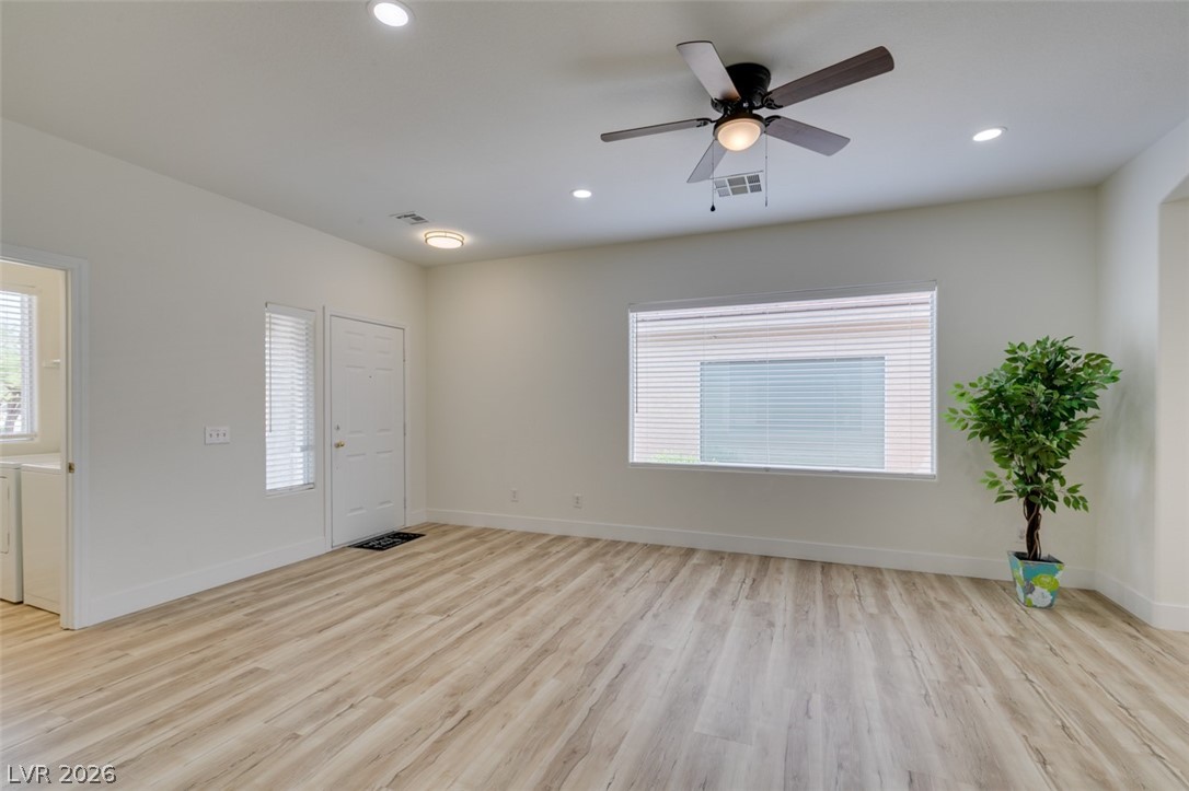 10959 Pumpkin Ridge Avenue Las Vegas, NV 89135 - Photo 5 of 51 A versatile living room with warm wood-tone new flooring and ample natural light, ready for personalization.