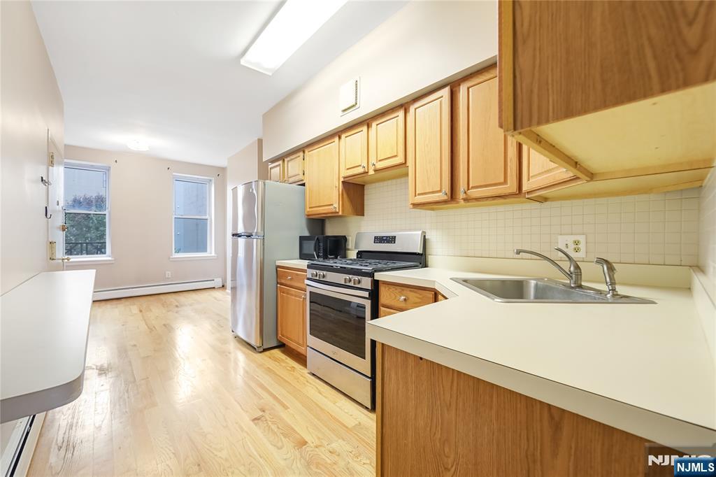 523 Adams Street, Unit 3 Hoboken, NJ 07030 - Photo 1 of 19 a kitchen with stainless steel appliances granite countertop a sink a stove and a refrigerator