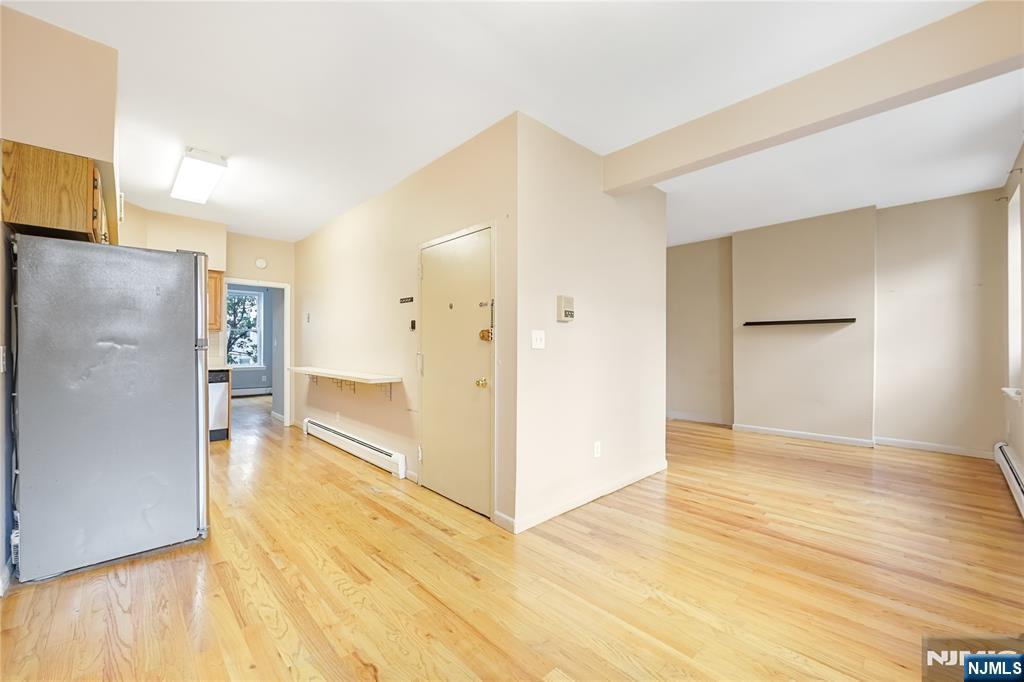 523 Adams Street, Unit 3 Hoboken, NJ 07030 - Photo 6 of 19 a view of a big room with wooden floor and a refrigerator