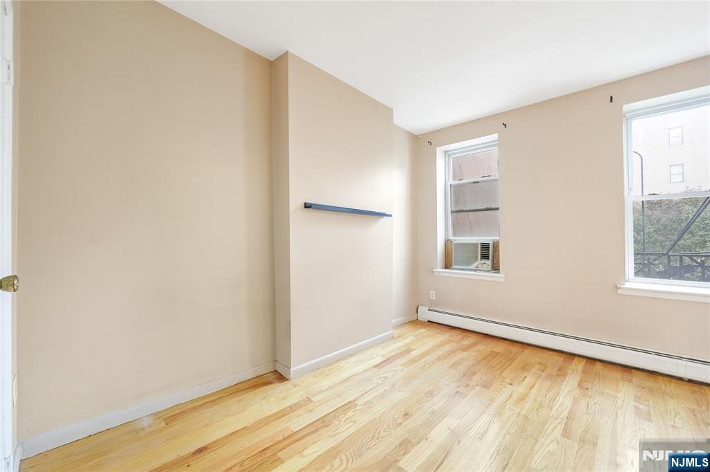 523 Adams Street, Unit 3 Hoboken, NJ 07030 - Photo 9 of 19 a view of an empty room with wooden floor and a window