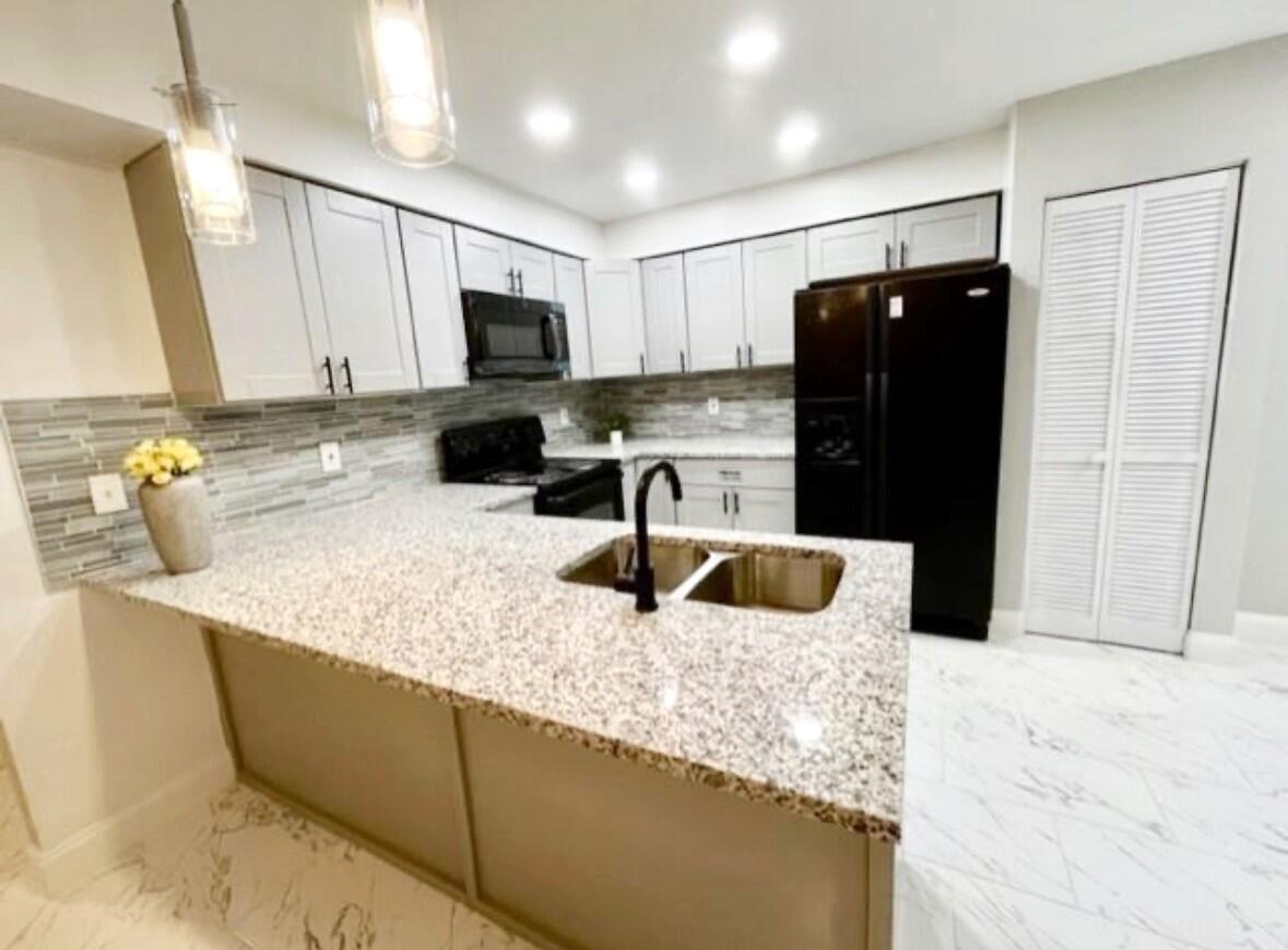 4372 Lamson Avenue Spring Hill, FL 34608 - Photo 5 of 8 a kitchen with stainless steel appliances granite countertop a sink and a refrigerator