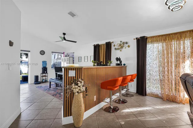 a kitchen with granite countertop stainless steel appliances a stove a refrigerator a sink a dining table and chairs