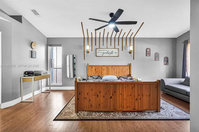 a bedroom with a bed lamp and a large window