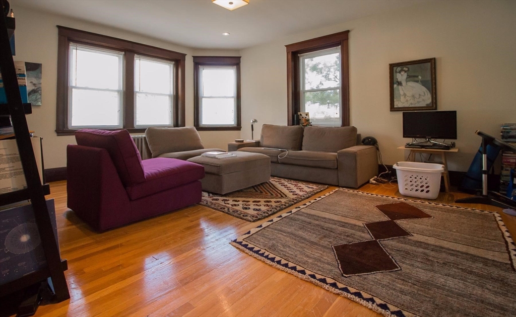 55 Franklin Street, Unit 1 Brookline, MA 02445 - Photo 2 of 12 a living room with furniture and a flat screen tv