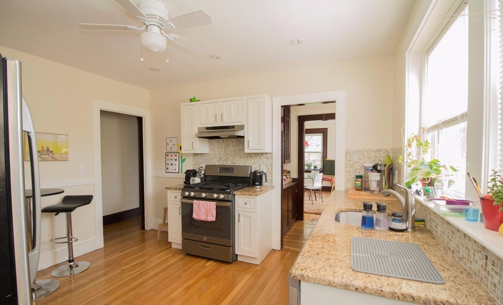 55 Franklin Street, Unit 1 Brookline, MA 02445 - Photo 5 of 12 a kitchen with stainless steel appliances granite countertop a stove and a refrigerator