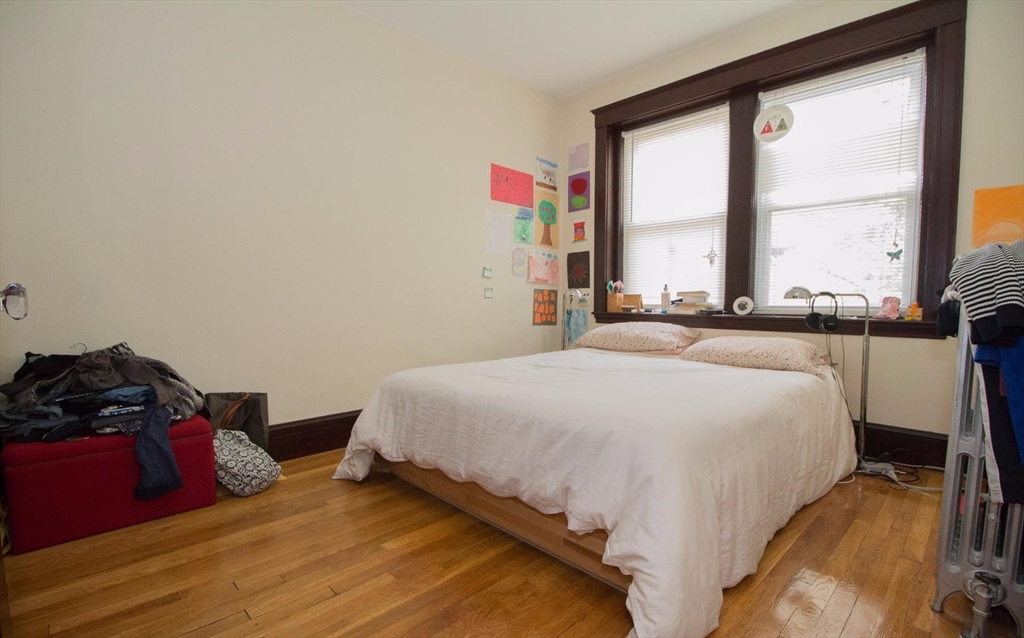 55 Franklin Street, Unit 1 Brookline, MA 02445 - Photo 8 of 12 a bedroom with a bed and a large window