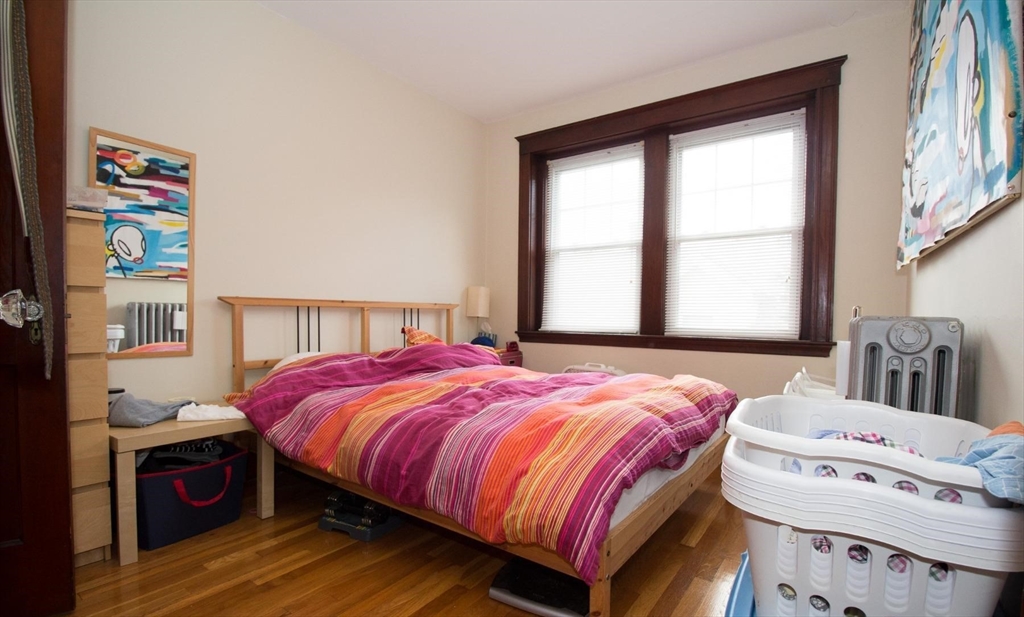 55 Franklin Street, Unit 1 Brookline, MA 02445 - Photo 9 of 12 a bedroom with a bed and a large window