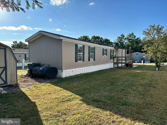 a view of a house with backyard and trees