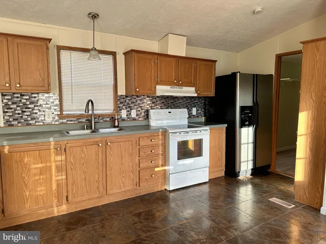 a kitchen with stainless steel appliances white cabinets and wooden floors