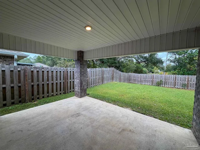 a view of a backyard with wooden fence