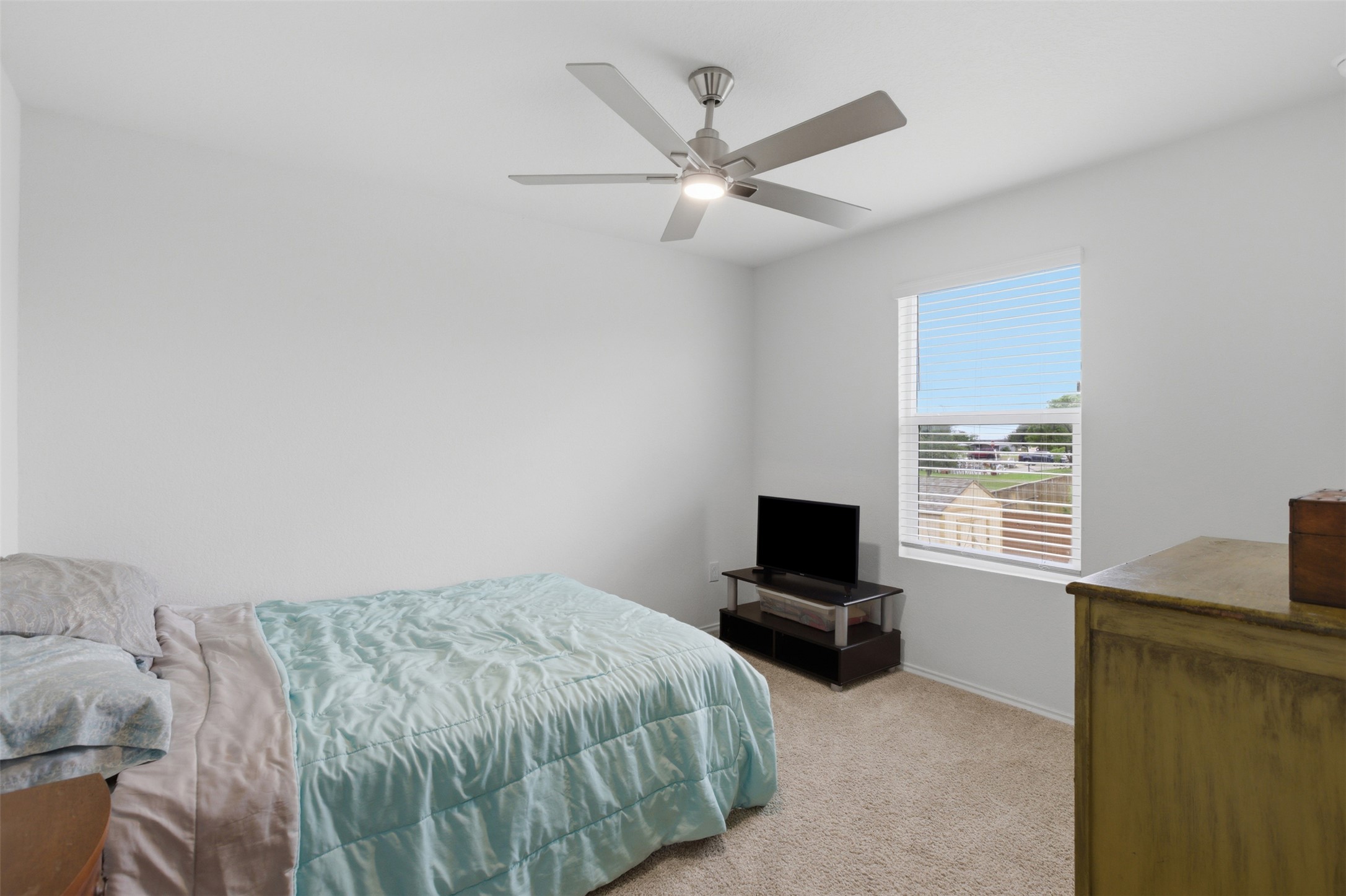 19017 Romano Drive Elgin, TX 78621 - Photo 21 of 33 Bright room featuring a window with horizontal blinds, a ceiling fan with integrated lighting, and neutral carpeting