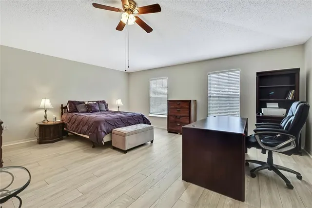 a spacious bedroom with a bed a dresser and flat screen tv