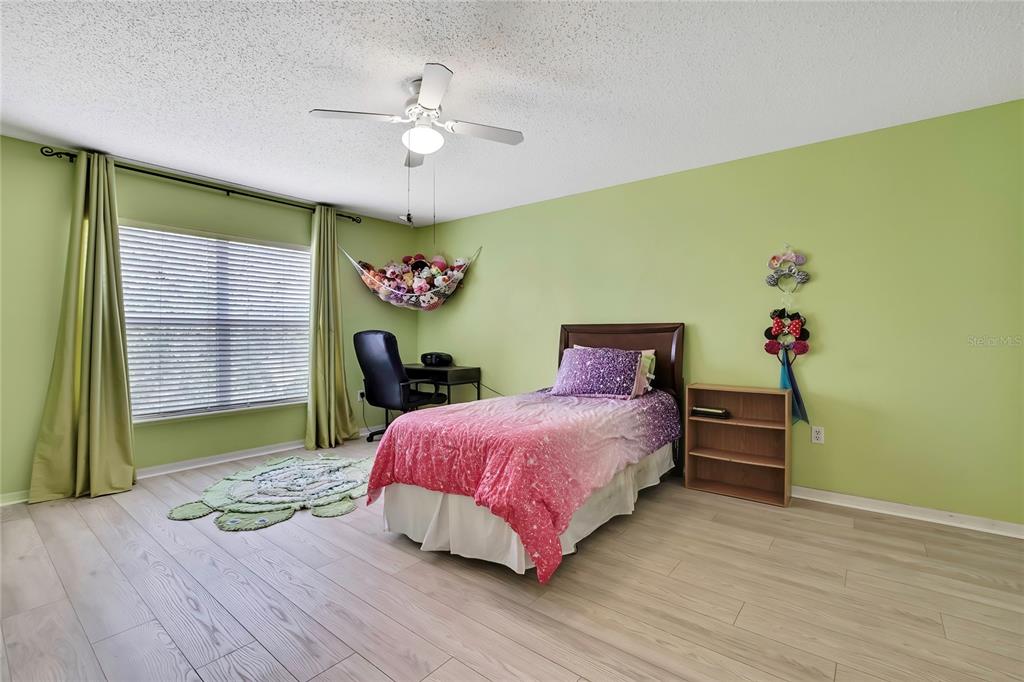 11257 Persimmon Avenue Weeki Wachee, FL 34614 - Photo 23 of 50 a bedroom with a bed and a chandelier