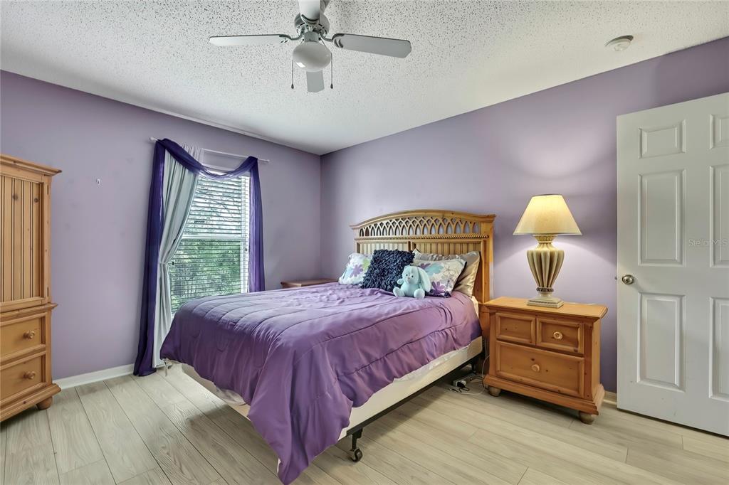 11257 Persimmon Avenue Weeki Wachee, FL 34614 - Photo 29 of 50 a bedroom with a bed a chandelier and dresser
