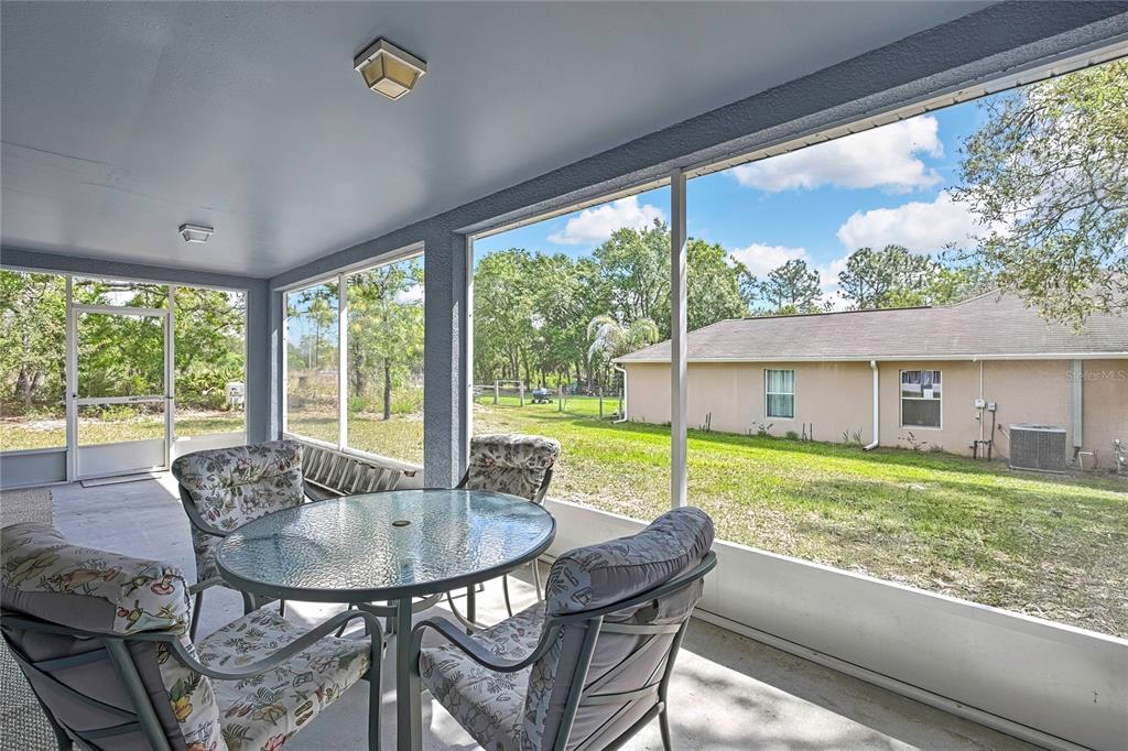 11257 Persimmon Avenue Weeki Wachee, FL 34614 - Photo 33 of 50 a view of a patio with a table chairs and a backyard