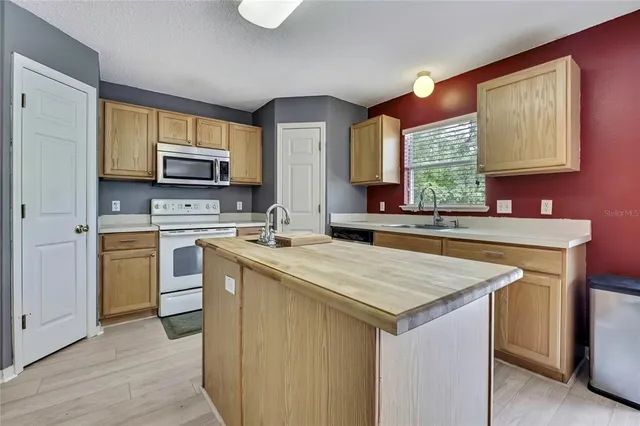 a kitchen with a stove a sink and a refrigerator