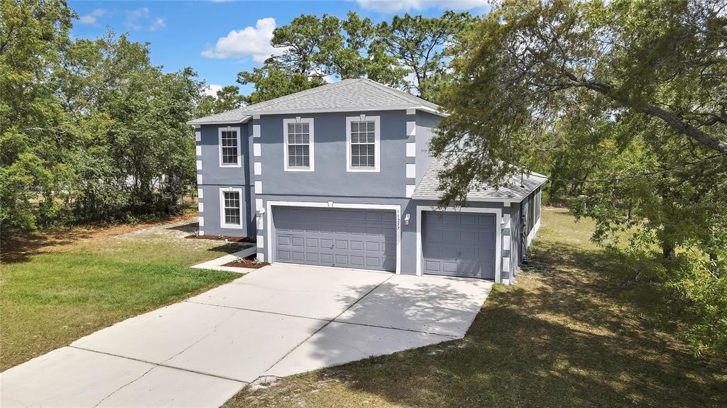 11257 Persimmon Avenue Weeki Wachee, FL 34614 - Photo 47 of 50 a front view of a house with a yard and garage