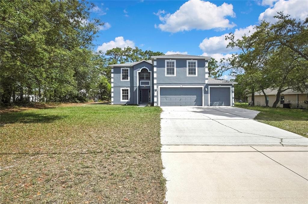11257 Persimmon Avenue Weeki Wachee, FL 34614 - Photo 48 of 50 a front view of a house with a garden and trees