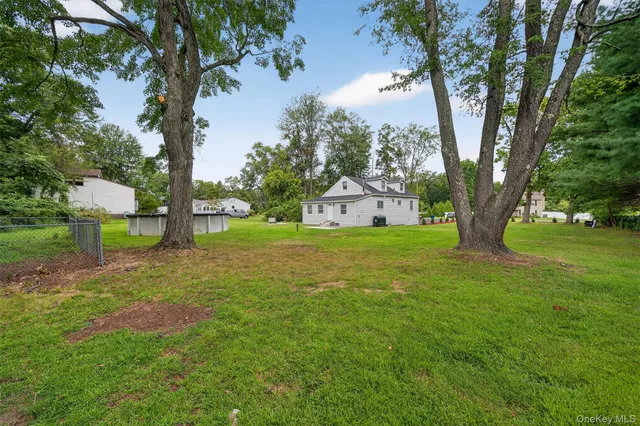 a view of a house with backyard and trees