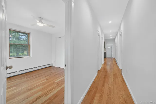 a view of a hallway with wooden floor and a chandelier