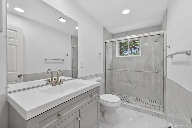 a bathroom with a sink a toilet and shower