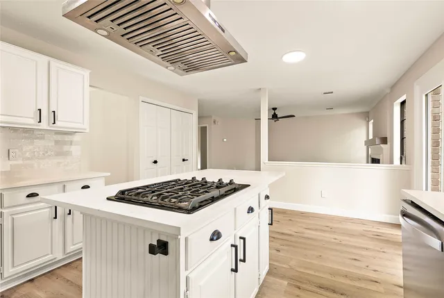 a kitchen with granite countertop a stove cabinets and wooden floor