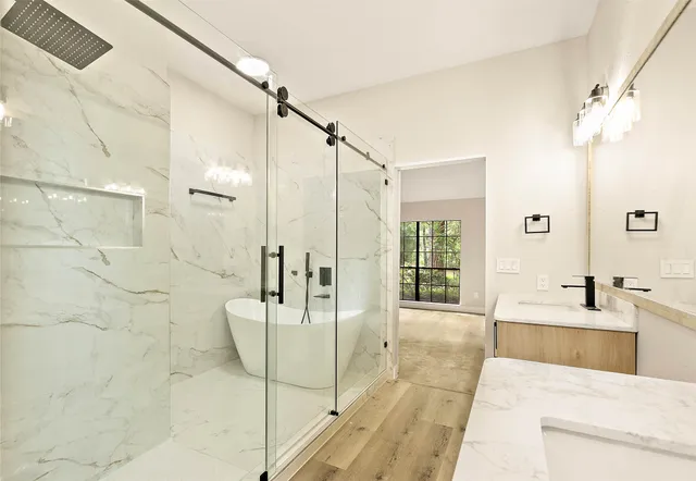 a bathroom with a sink a mirror a vanity and shower