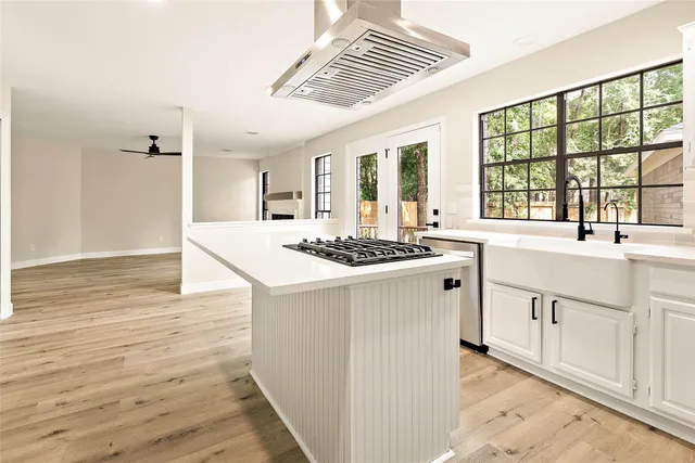 a kitchen with stainless steel appliances granite countertop a sink and a wooden floors