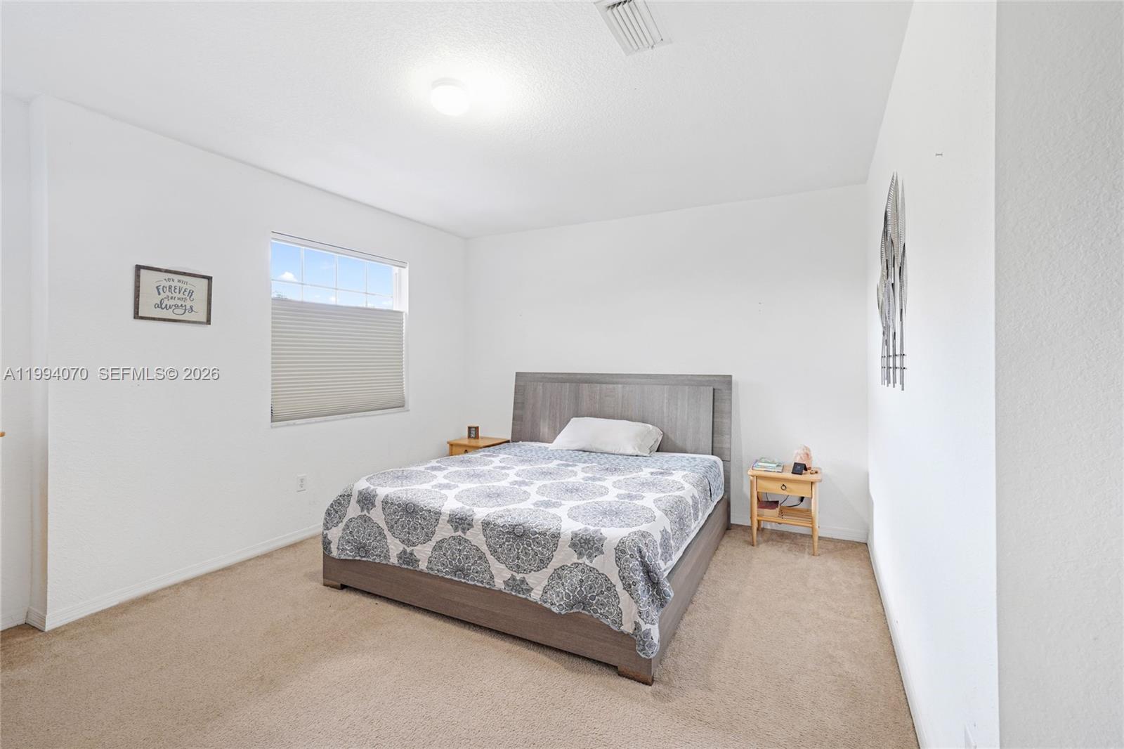 12763 Southwest 50th Street Miramar, FL 33027 - Photo 17 of 38 a bedroom with a bed and a night stand
