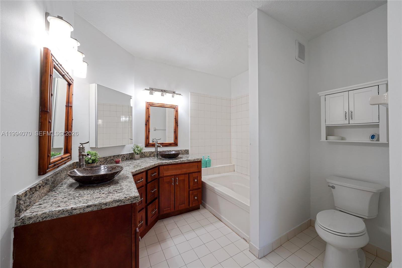 12763 Southwest 50th Street Miramar, FL 33027 - Photo 19 of 38 a bathroom with a granite countertop sink mirror and toilet