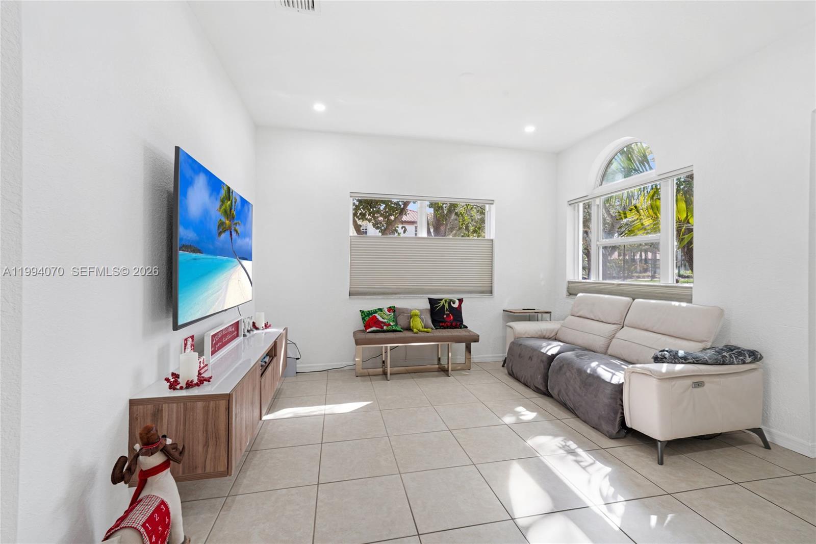 12763 Southwest 50th Street Miramar, FL 33027 - Photo 2 of 38 a living room with furniture and a flat screen tv