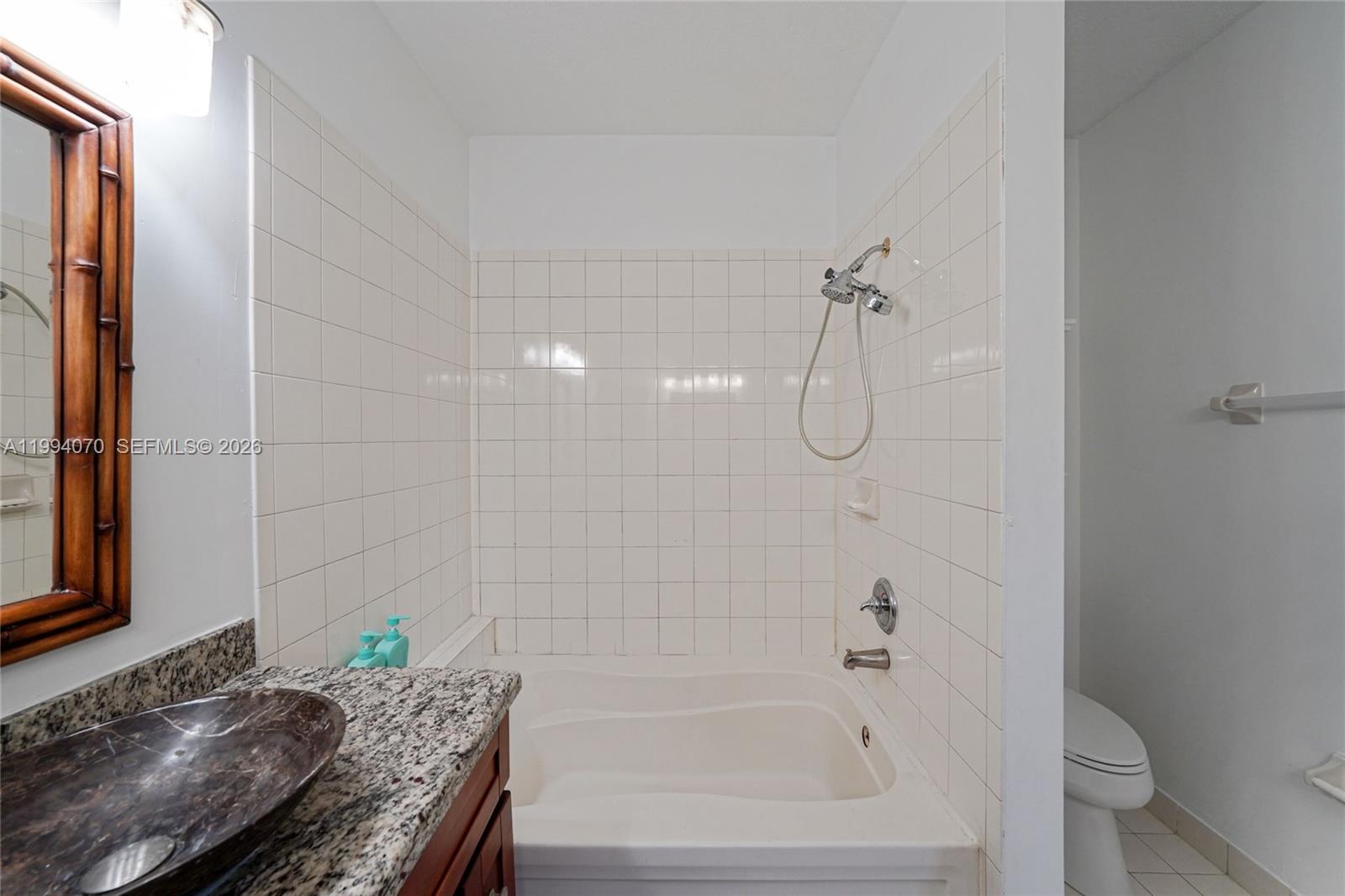 12763 Southwest 50th Street Miramar, FL 33027 - Photo 22 of 38 a bathroom with a granite countertop bathtub shower and toilet