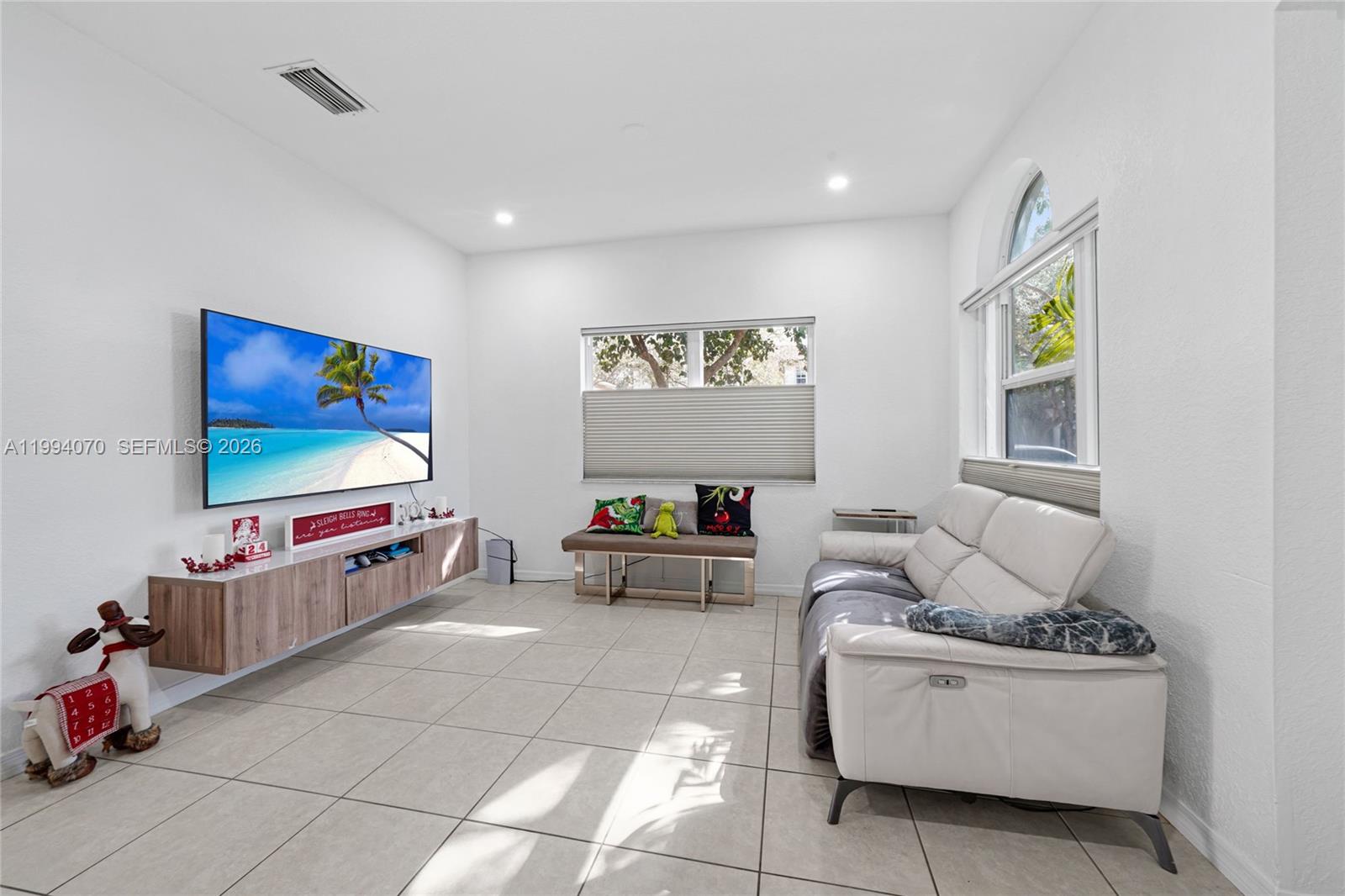 12763 Southwest 50th Street Miramar, FL 33027 - Photo 3 of 38 a living room with furniture and a flat screen tv