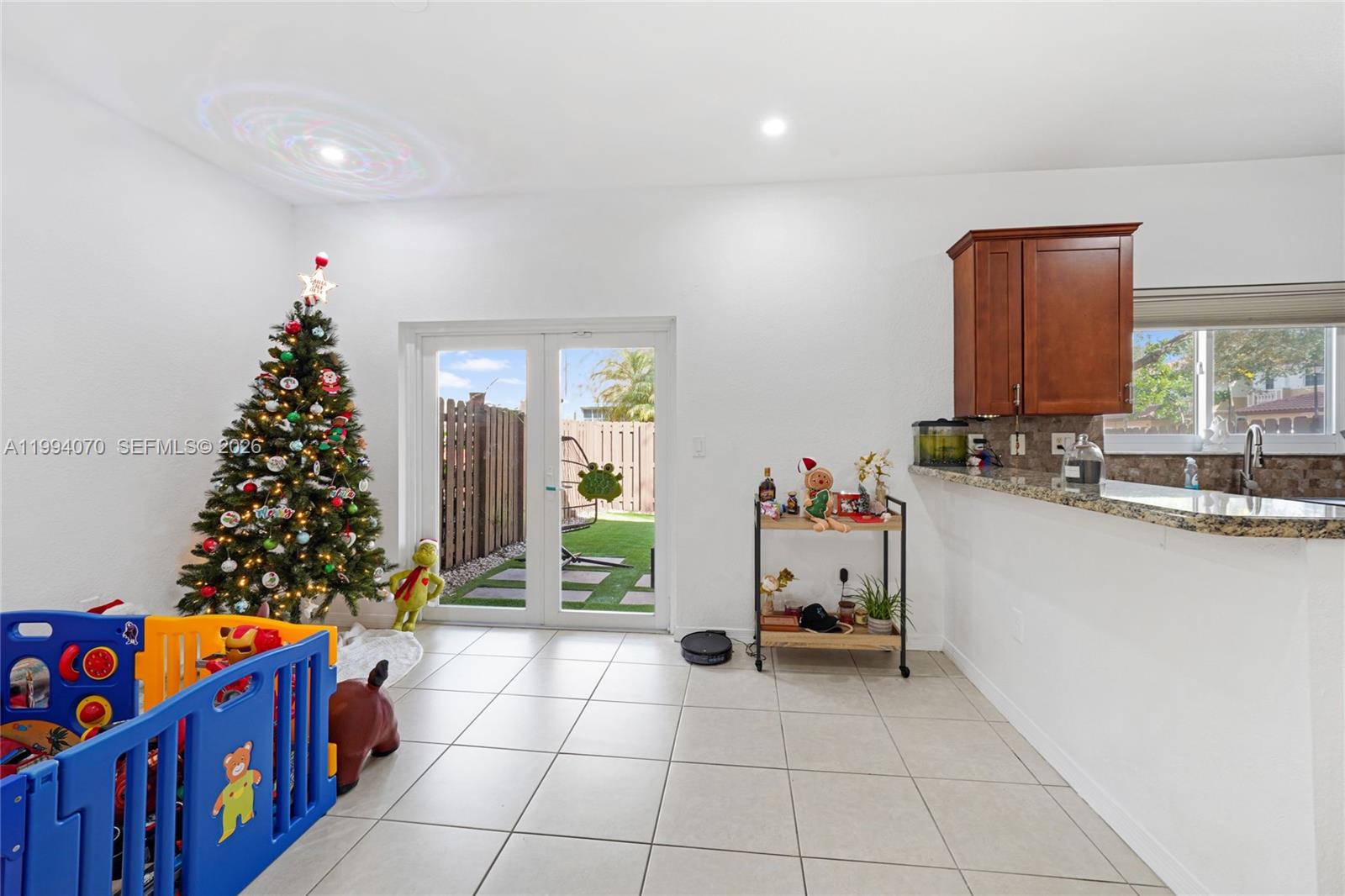 12763 Southwest 50th Street Miramar, FL 33027 - Photo 7 of 38 a hallway with a flower garden and table